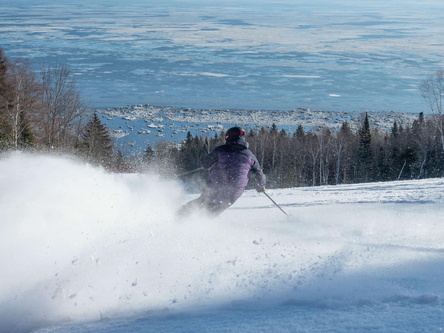 person makes turns down le massif on a groomer day
